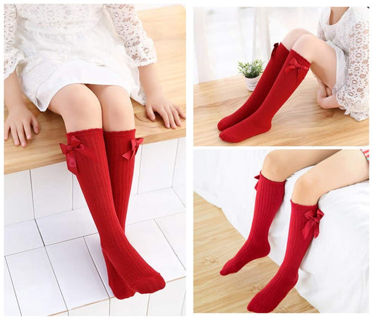 Five pairs of knee-high socks with a bow design for girls, sizes 3–12 toddlers, available in a variety of colors.